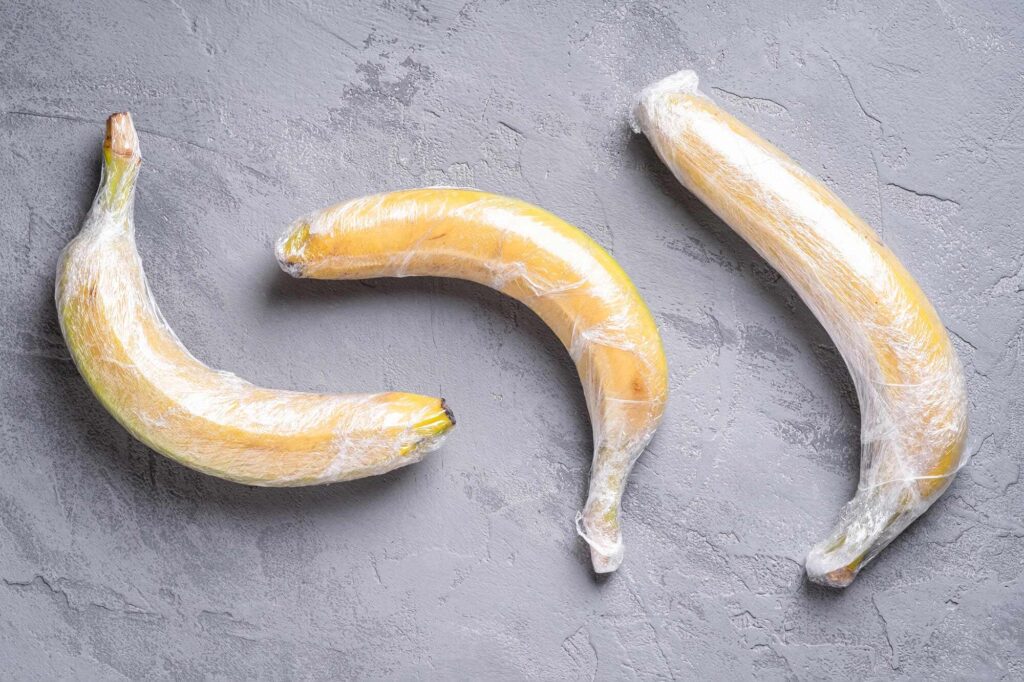 Three bananas wrapped in plastic film