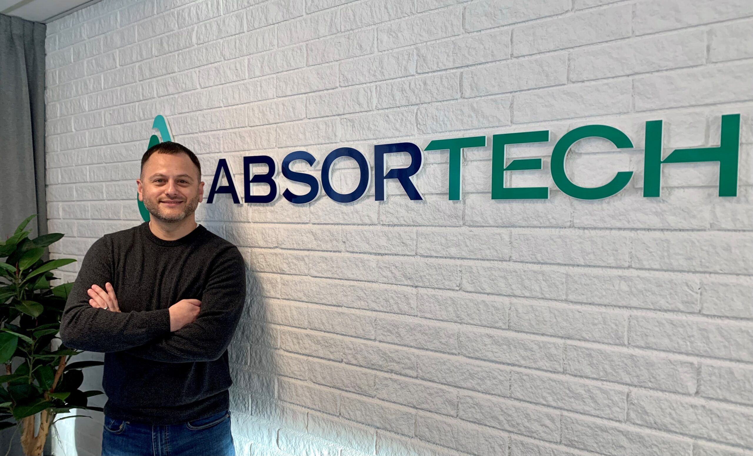 Vicente Reynoso in front of an Absortech sign.