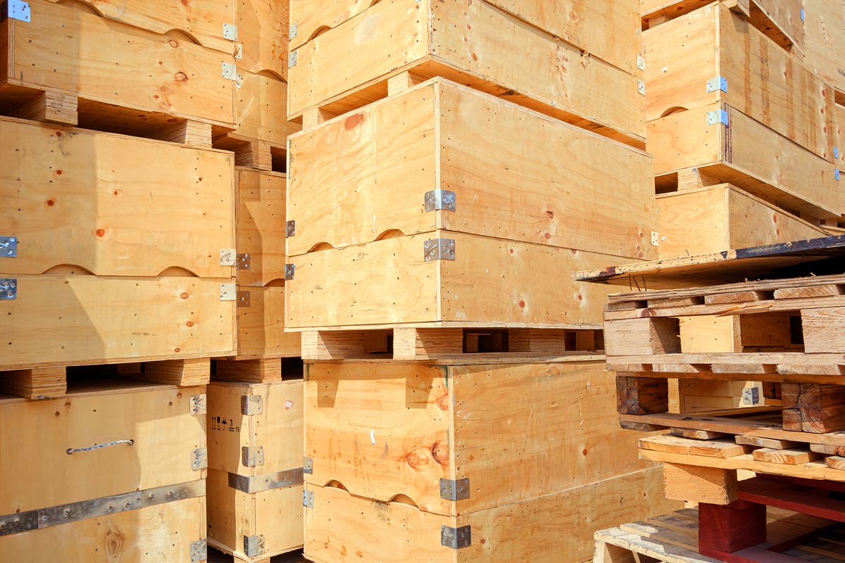 Pilas de cajas y palés de madera en un almacén.