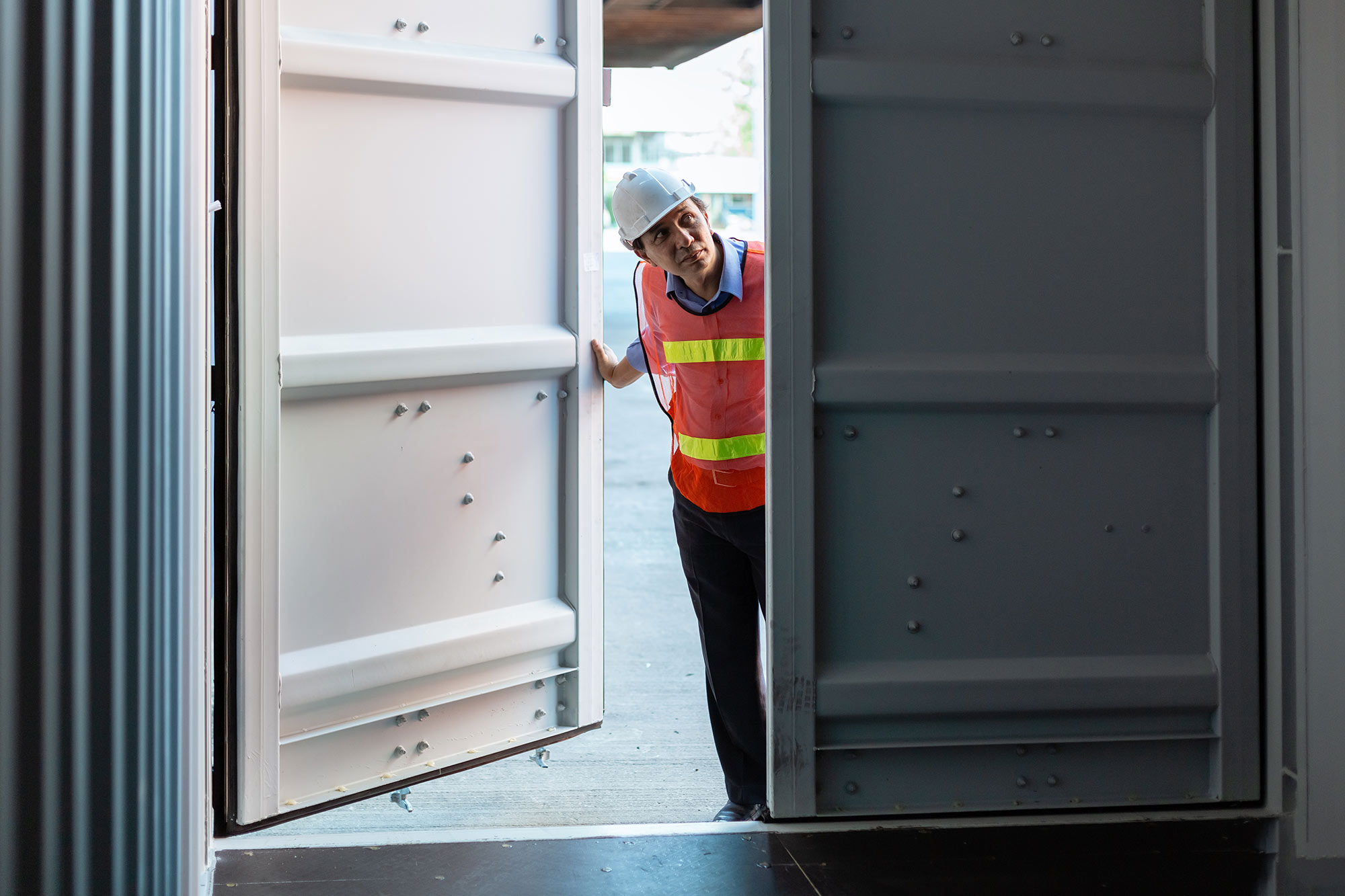 Man in hard hat checking container